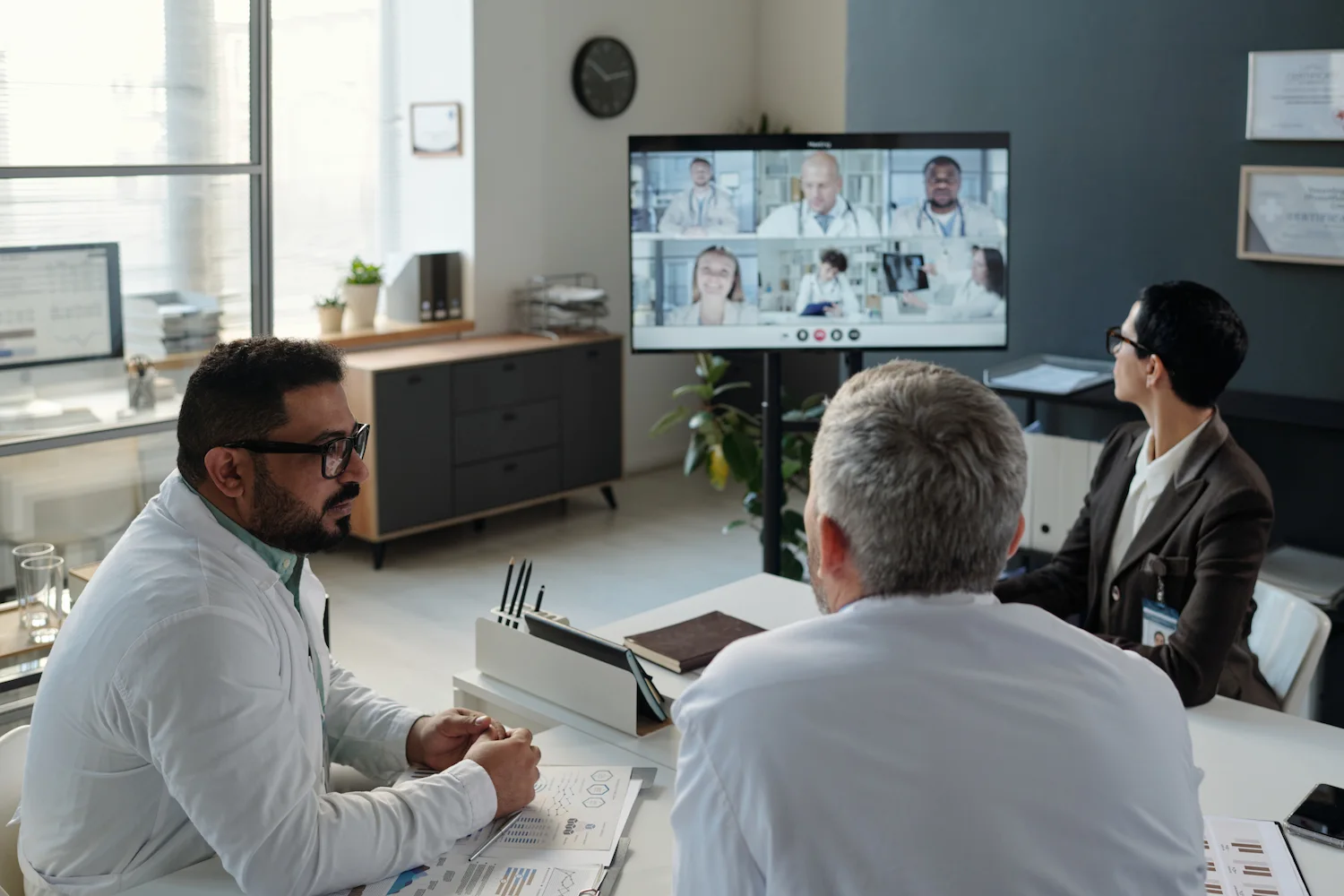 Equipo de profesionales de la salud en una reunión híbrida de trabajo colaborativo